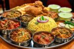 Traditional Indian Thali Feast on a Wooden Table – Authentic Homemade Indian Food Platter with Curry, Rice, Bread, and Delicious Side Dishes