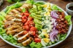 Fresh Cobb Salad on a Rustic Wooden Table – Easy Healthy American Salad Recipe with Chicken, Bacon, Avocado, Eggs, and Fresh Vegetables